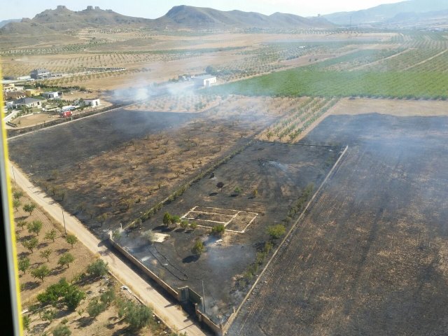 Bomberos y brigadas forestales, con apoyo de helicóptero, extinguen un incendio en Jumilla